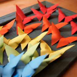 Un tableau avec une envolée de papillons en origami