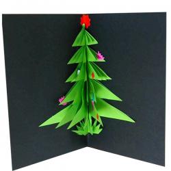 Réalisation d'une carte de voeux avec un gros sapin en relief. Le sapin est découpé dans du papier vert puis il est collé sur la carte.