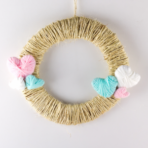 La couronne de la Saint Valentin de Tête à modeler est une jolie couronne en laine pleine de petits coeurs en laine.