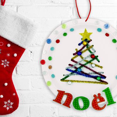 Découvrez un bricolage facile et coloré qui permettra aux enfants de fabriquer une jolie suspension de Noël pour décorer la maison ! Pour ce bricolage vous n'aurez besoin que de matériel simple : assiette en carton, chenilles, boutons...
Une a