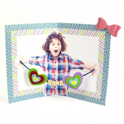 Découvrez comment réaliser une jolie carte pour la Fête des pères. En ouvrant la carte, papa aura la surprise de voir l'intérieur avec la photo de son petit loup ainsi que de jolies perles en bois. Une carte parfaite pour la Fête des pères, pour la Fête d